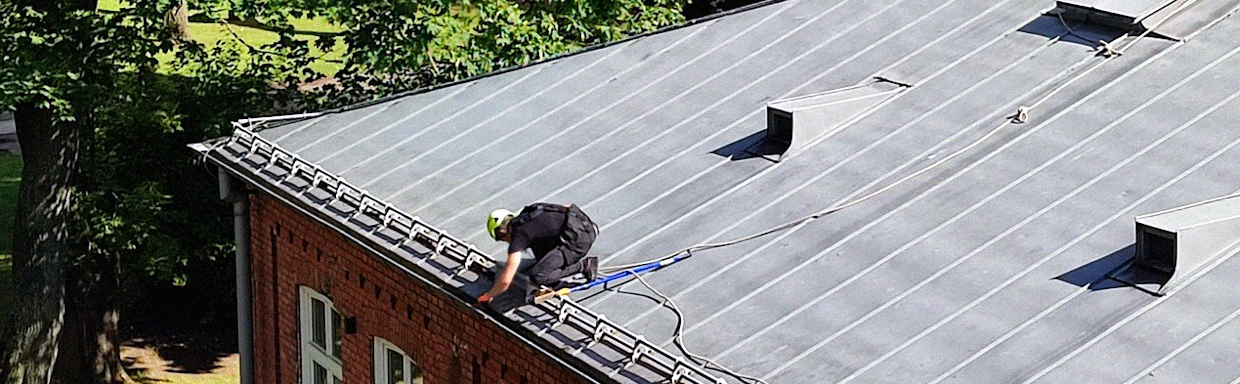 Technician performing gutter repairs in Toronto